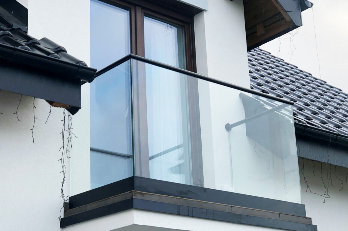 szklany balkon z czarnymi barierkami