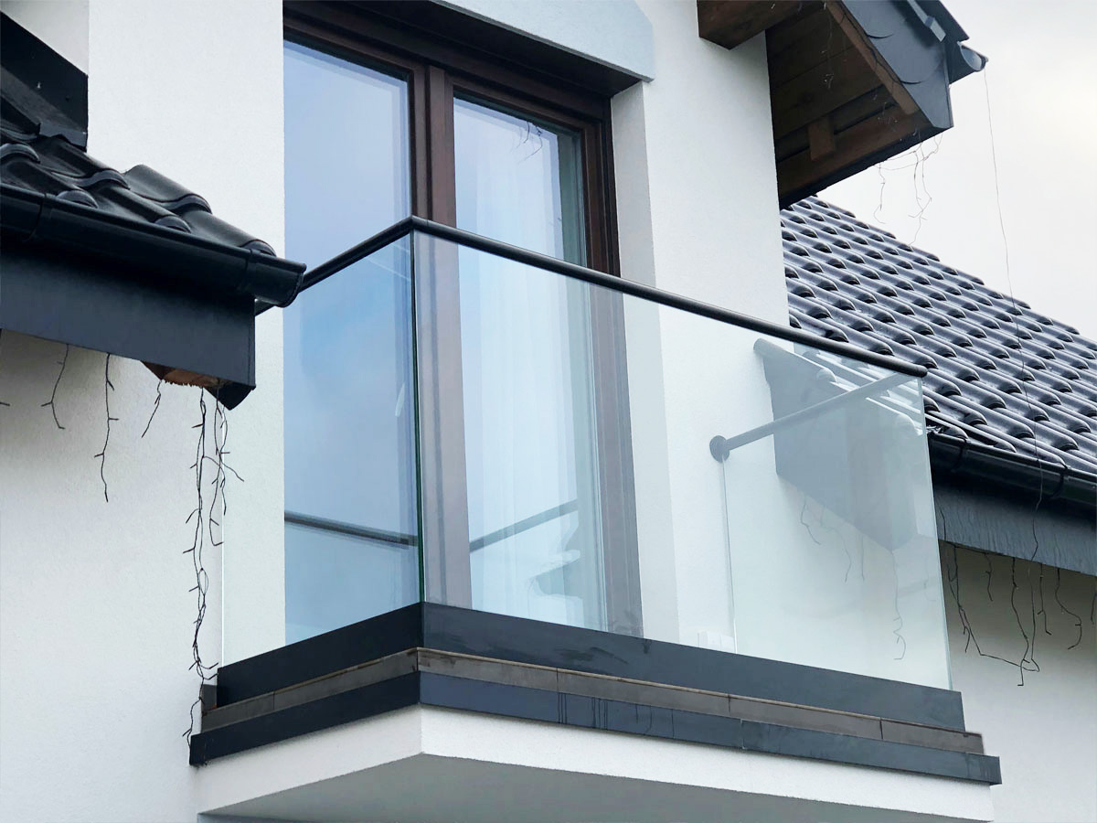 Szklany balkon z czarnymi barierkami