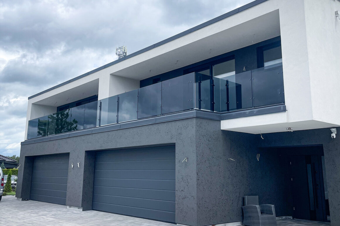Balustrady balkonowe szklane – nowoczesna realizacja z grafitowego szkła 10 mm 1 Balustrady balkonowe szklane na froncie budynku