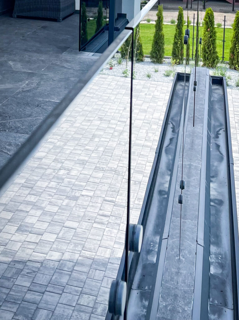 Balustrady balkonowe szklane – nowoczesna realizacja z grafitowego szkła 10 mm 3 Barierki szklane na balkon zbliżenie