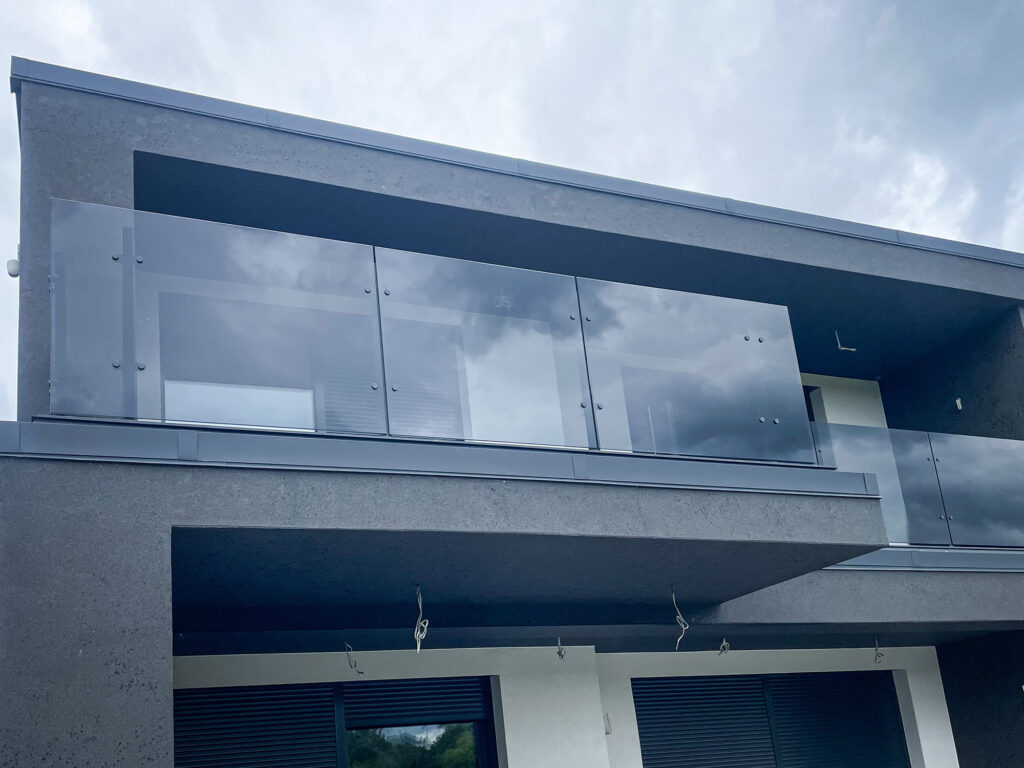 Balustrady balkonowe szklane – nowoczesna realizacja z grafitowego szkła 10 mm 6 Szklana balustrada na piętrze budynku