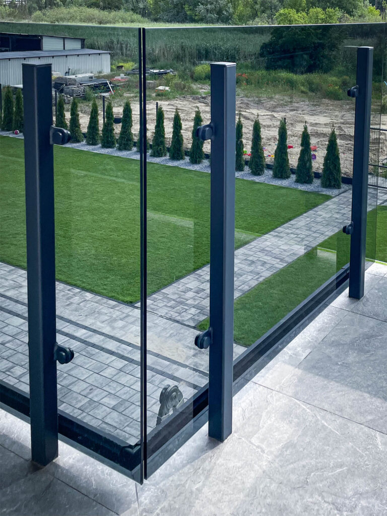 Balustrady balkonowe szklane – nowoczesna realizacja z grafitowego szkła 10 mm 2 słupki grafitowe w balustradzie na balkonie